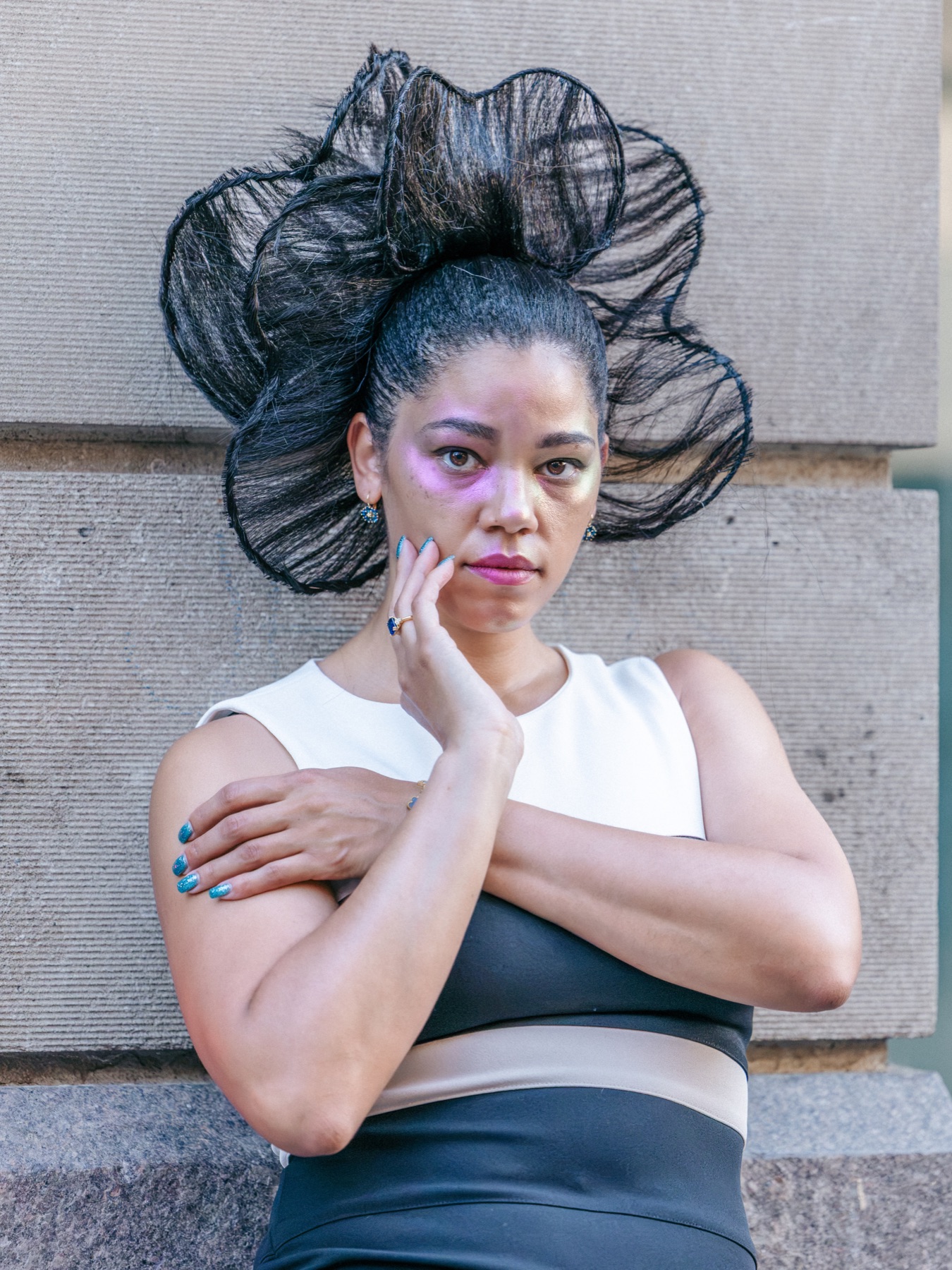 Model with sculptural black hair piece and lilac eye makeup